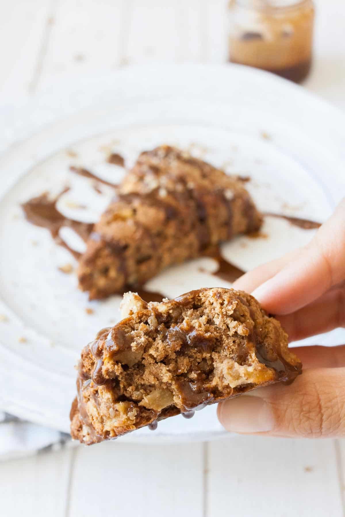 Hand holding a half eaten scone with glaze