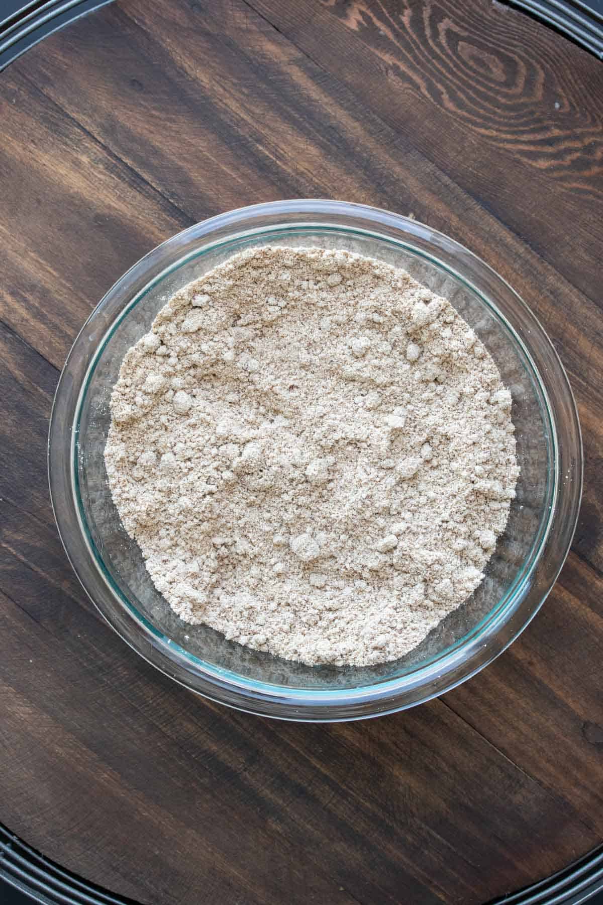 Glass bowl filled with a crumbly tan mixture