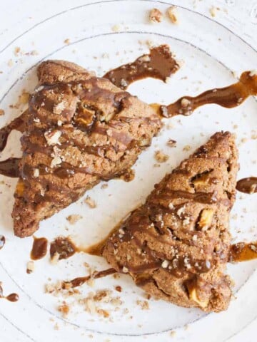 Two triangle shaped apple scones on a white plate