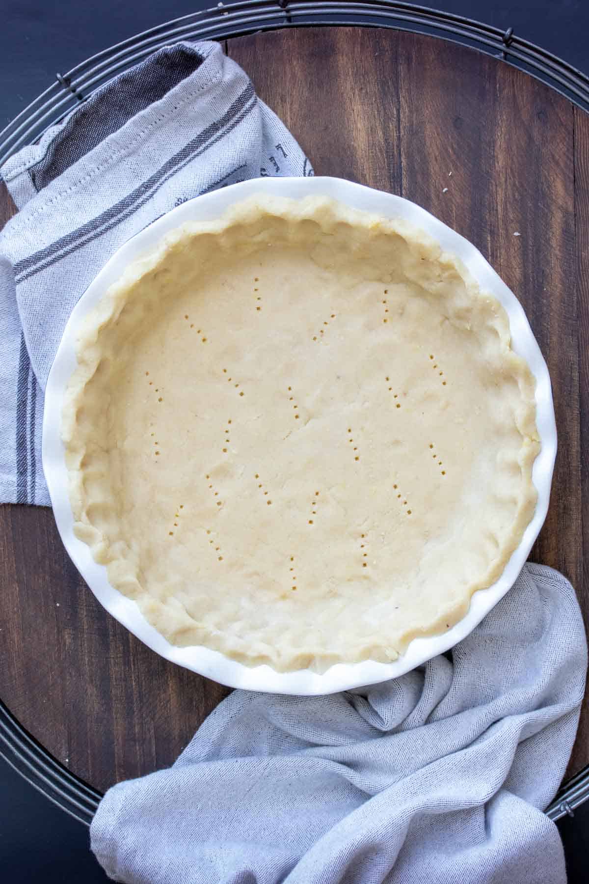 Top view of pie dough molded into a pie dish with scalloped edges