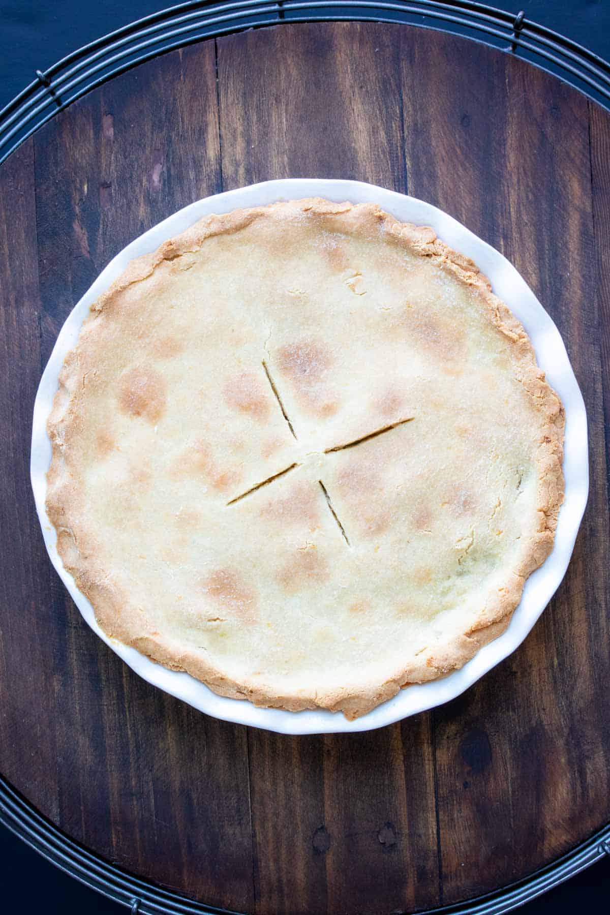 Top view of a baked vegetable pot pie on a wooden surface