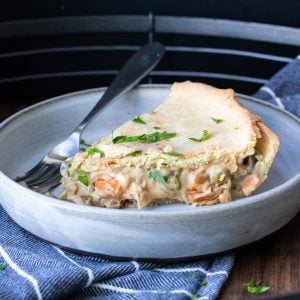 A grey plate with a piece of vegetable pot pie on it.