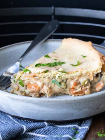 A grey plate with a piece of vegetable pot pie on it.