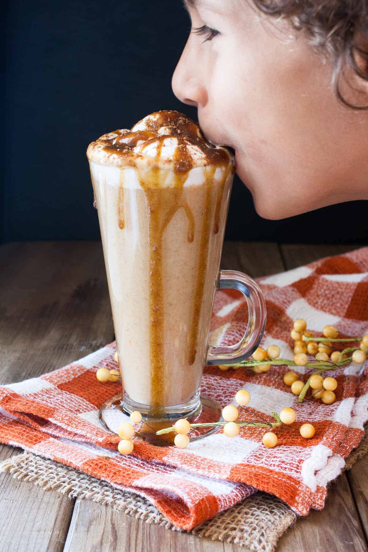 Boy taking a sip of a pumpkin spice latte with caramel drizzle