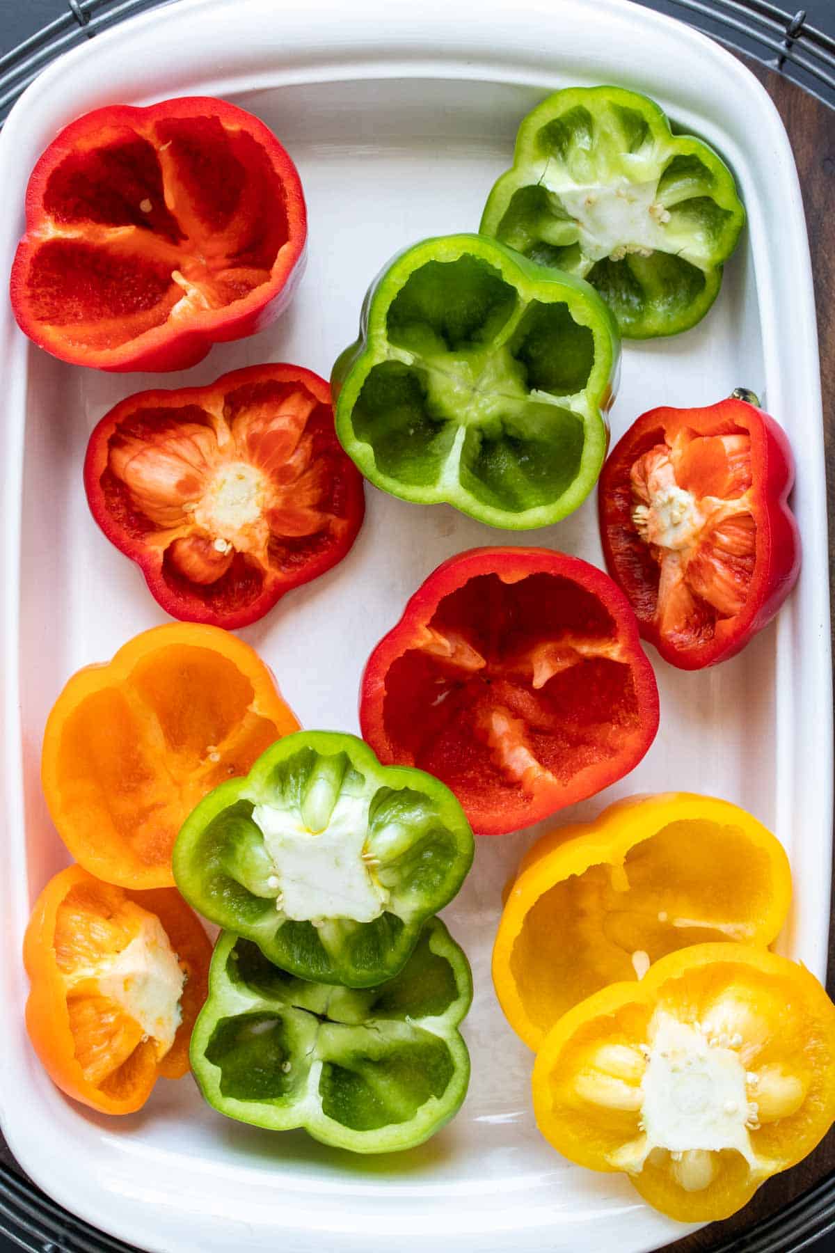 White baking dish with empty raw pepper with no tops in it