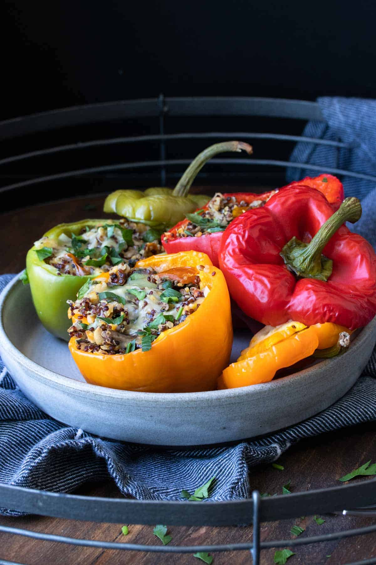 Grey plate with tri colored quinoa stuffed peppers