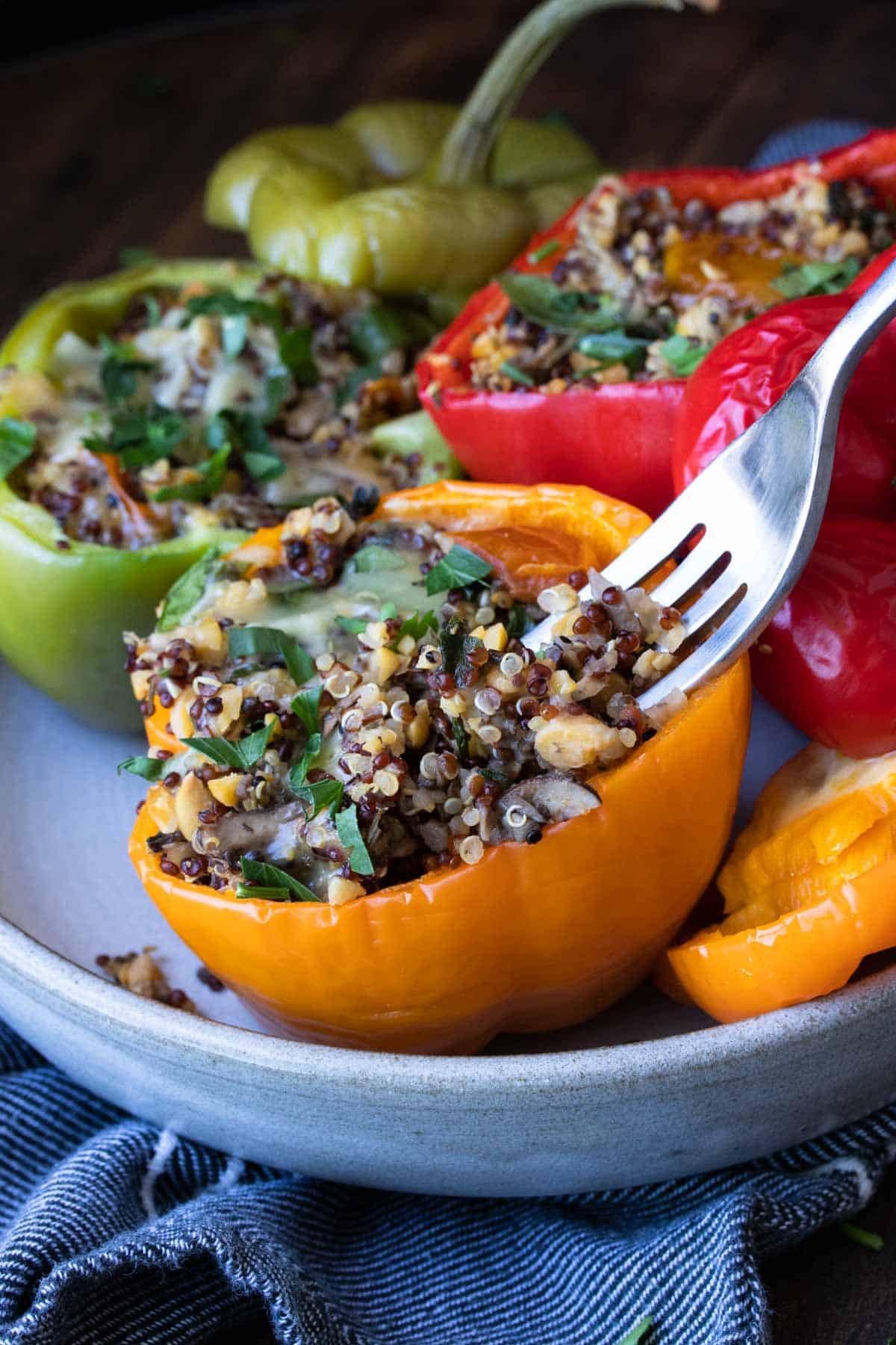 Fork getting a bite out of an orange quinoa stuffed pepper