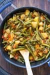 Cooked green beans with potatoes and tomatoes in a pan