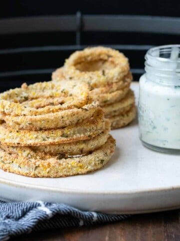 A pile of onion rings and creamy sauce on a plate