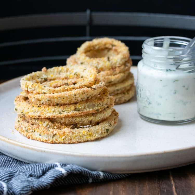 A pile of onion rings and creamy sauce on a plate