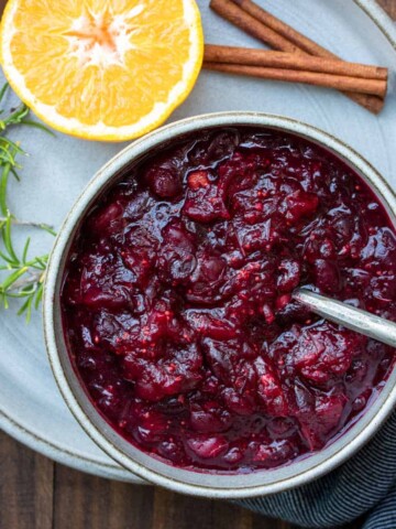 Bowl of cranberry sauce with a metal spoon in it