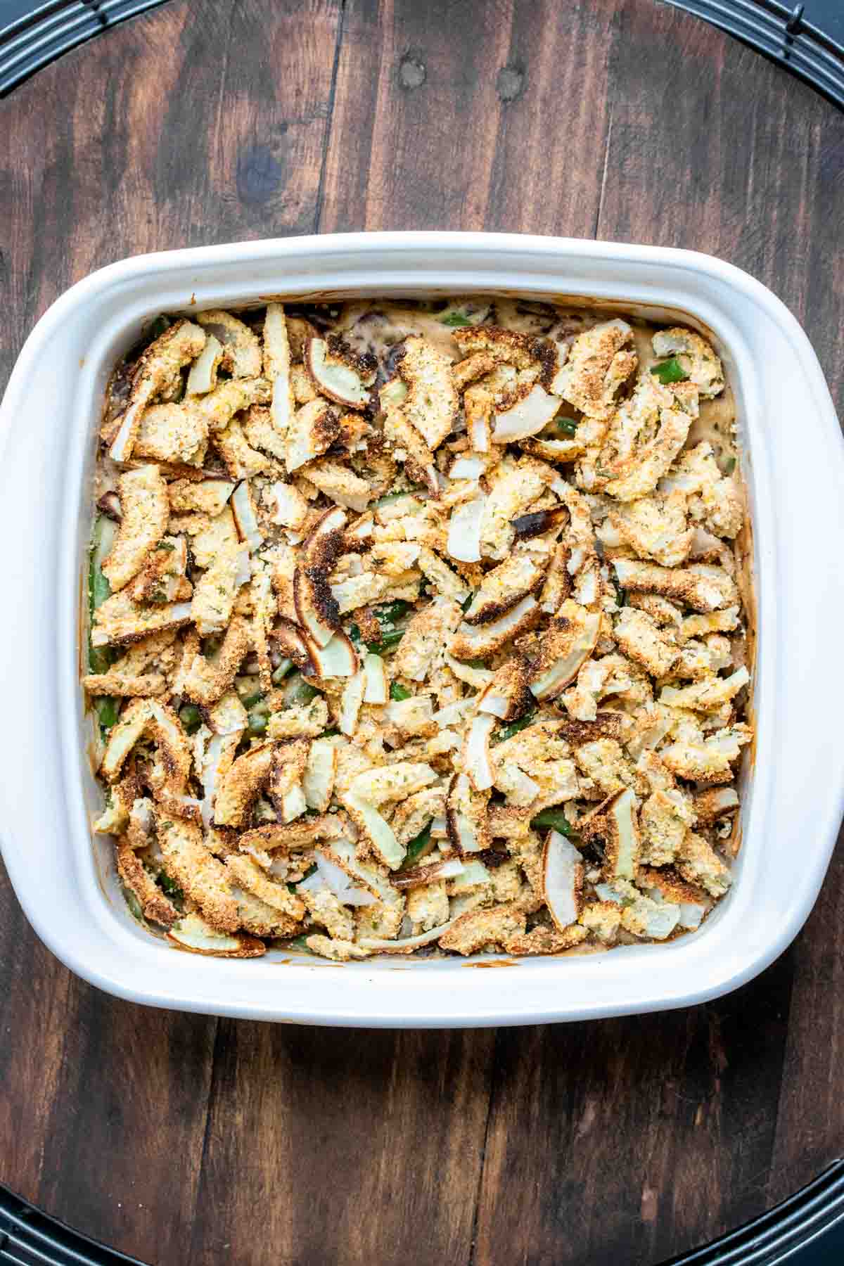 White baking dish with green bean casserole covered with crispy onions