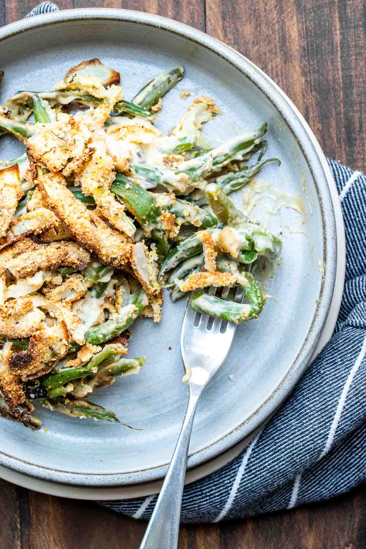 Fork getting a bite of green bean casserole from a plate