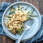 A grey plate with some green bean casserole and a fork on it.