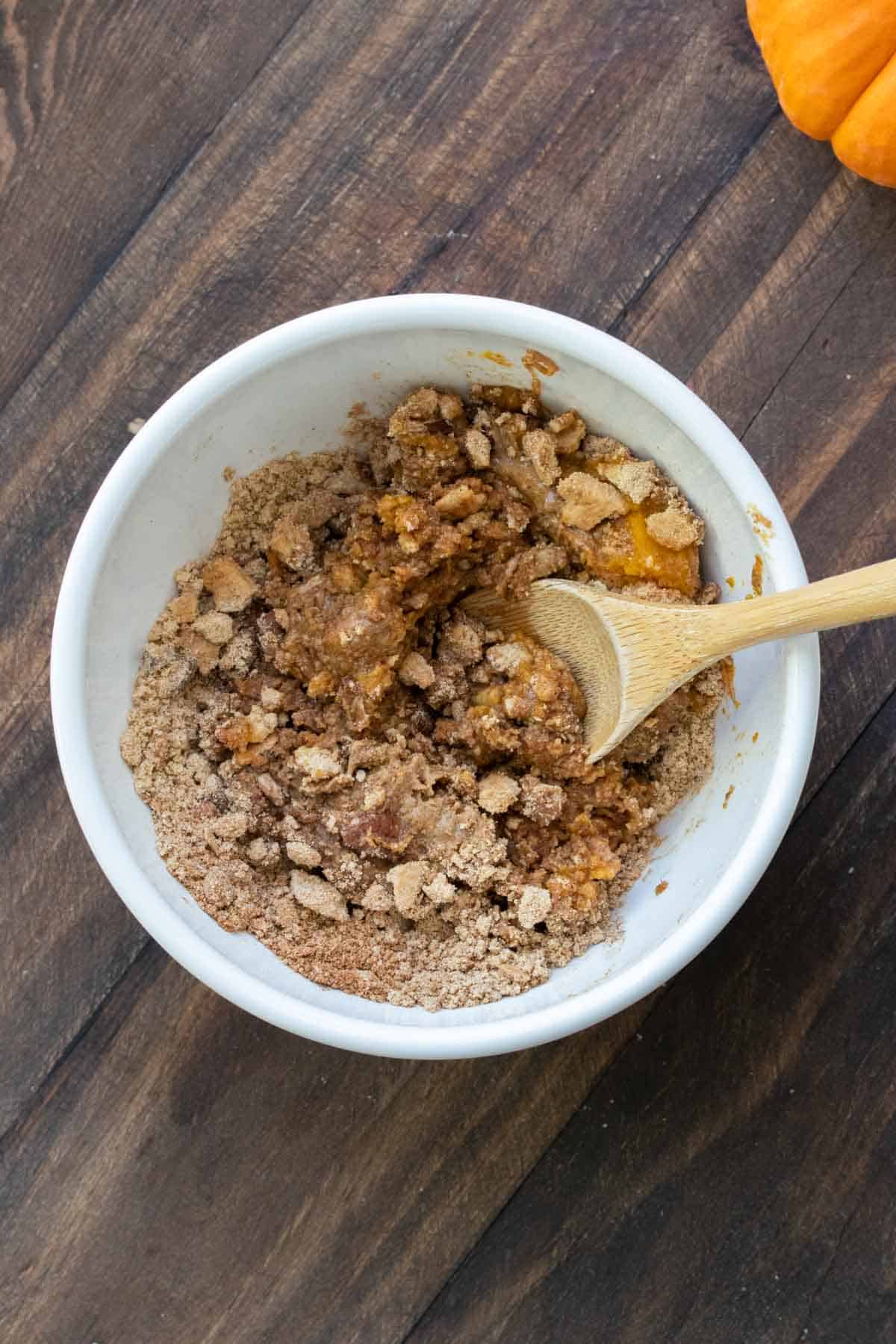 Ingredients for pumpkin energy balls being mixed in a white bowl