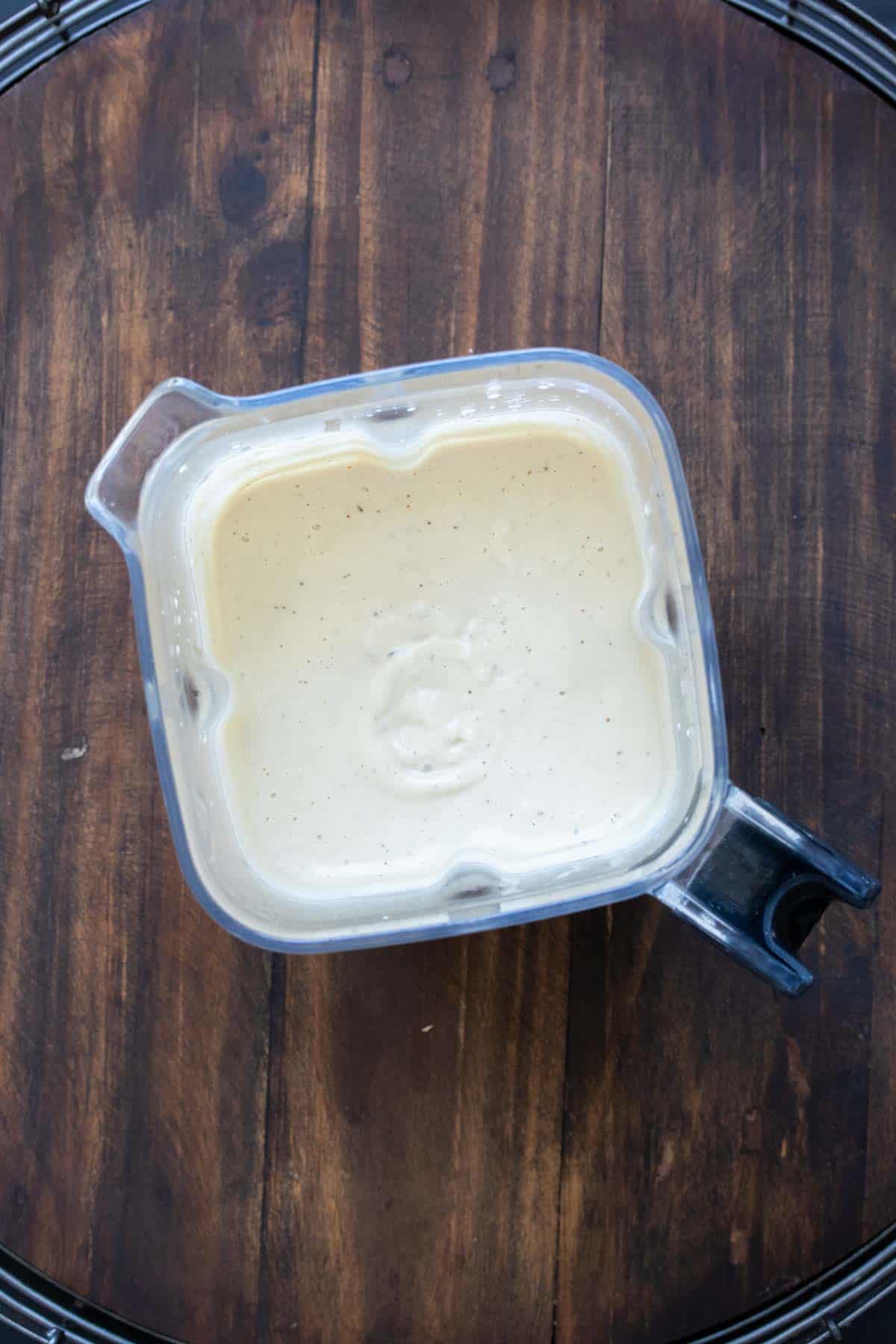 Top view of a blender with creamy Alfredo sauce inside