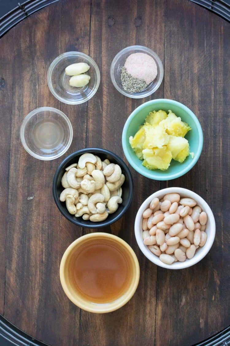 Different types of bowls filled with ingredients for vegan Alfredo sauce