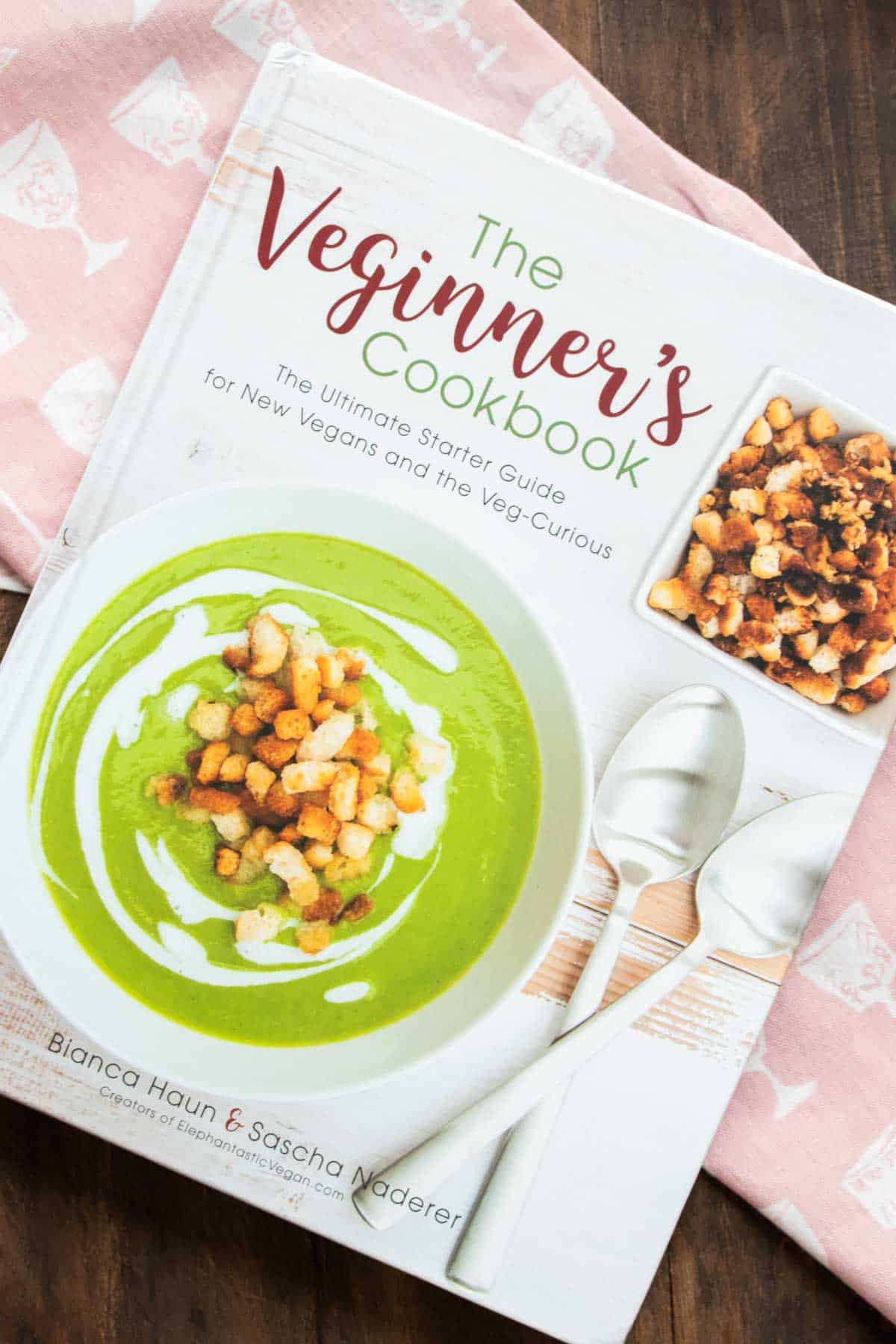 Cover of a white cookbook with a green soup on it