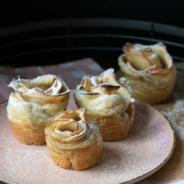 Pink plate with baked apple roses dessert on it