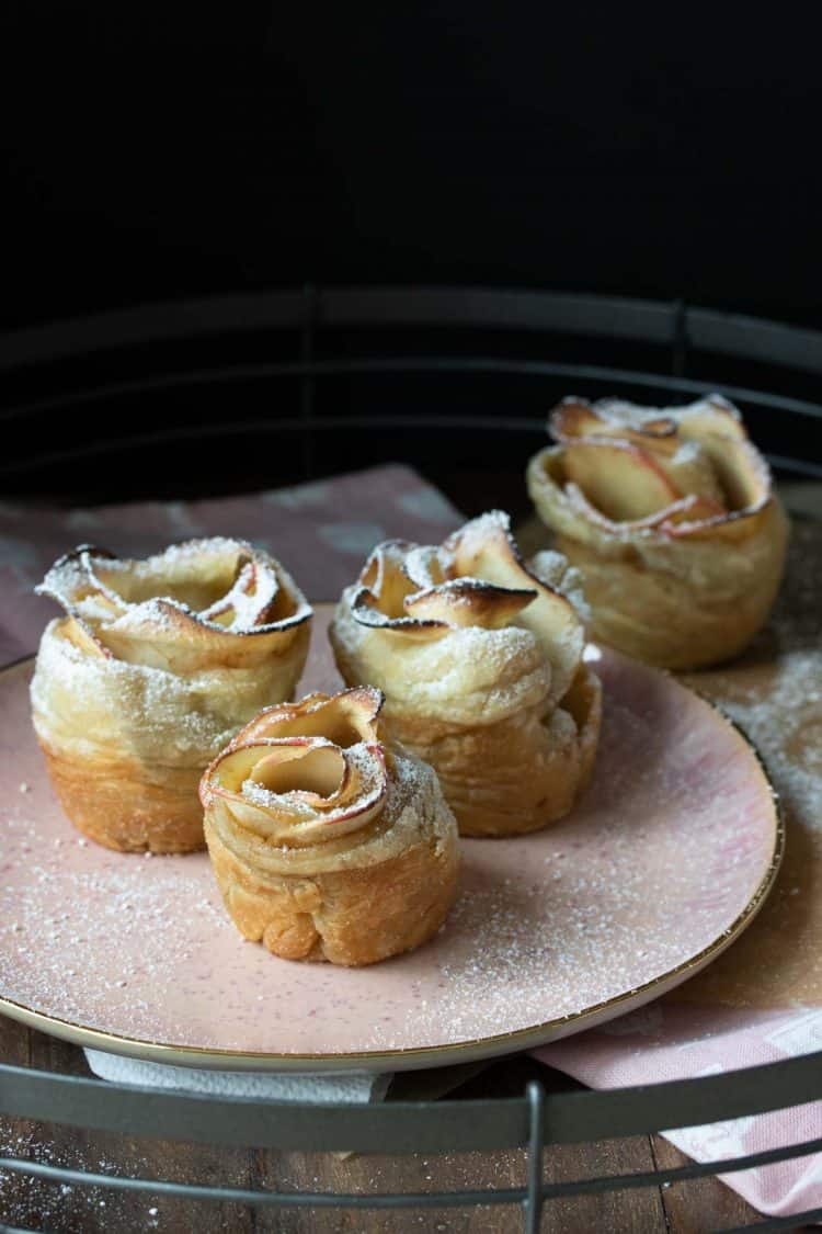 Pink plate with baked apple roses dessert on it