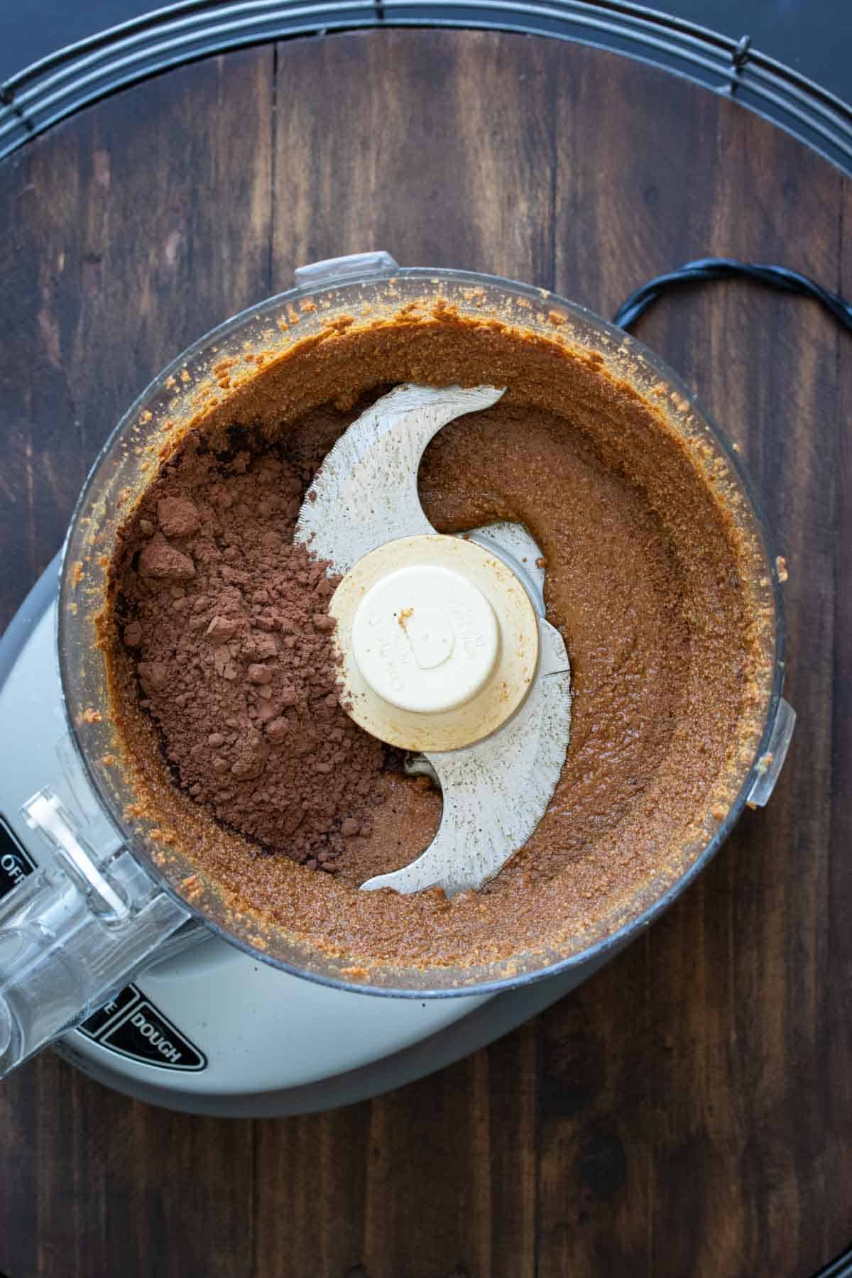 Food processor blending hazelnuts and cocoa powder