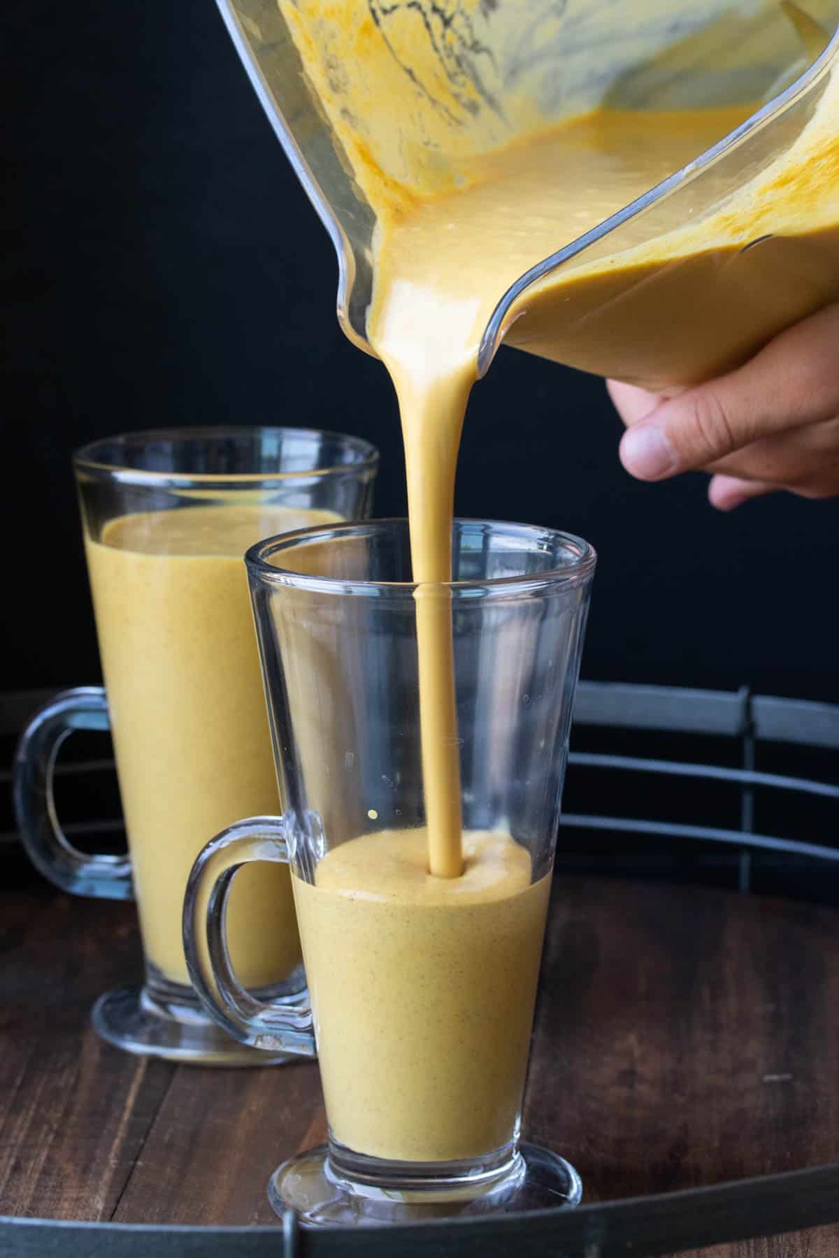 A pumpkin smoothie being poured into a glass jar