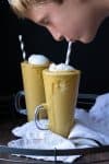 Kid taking a drink from a glass jar filled with a pumpkin pie smoothie