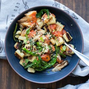 Tomatoes and broccoli over a bowl of gnocchi.