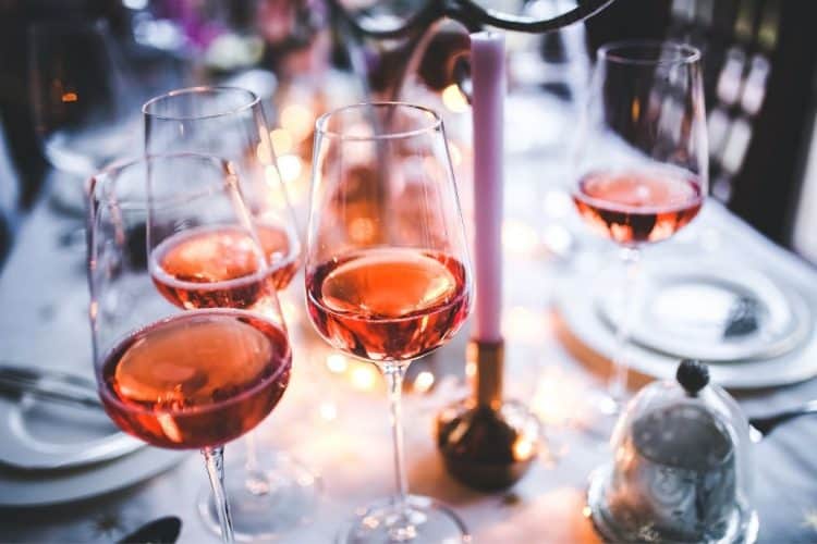 Four glasses on a table filled with rose wine