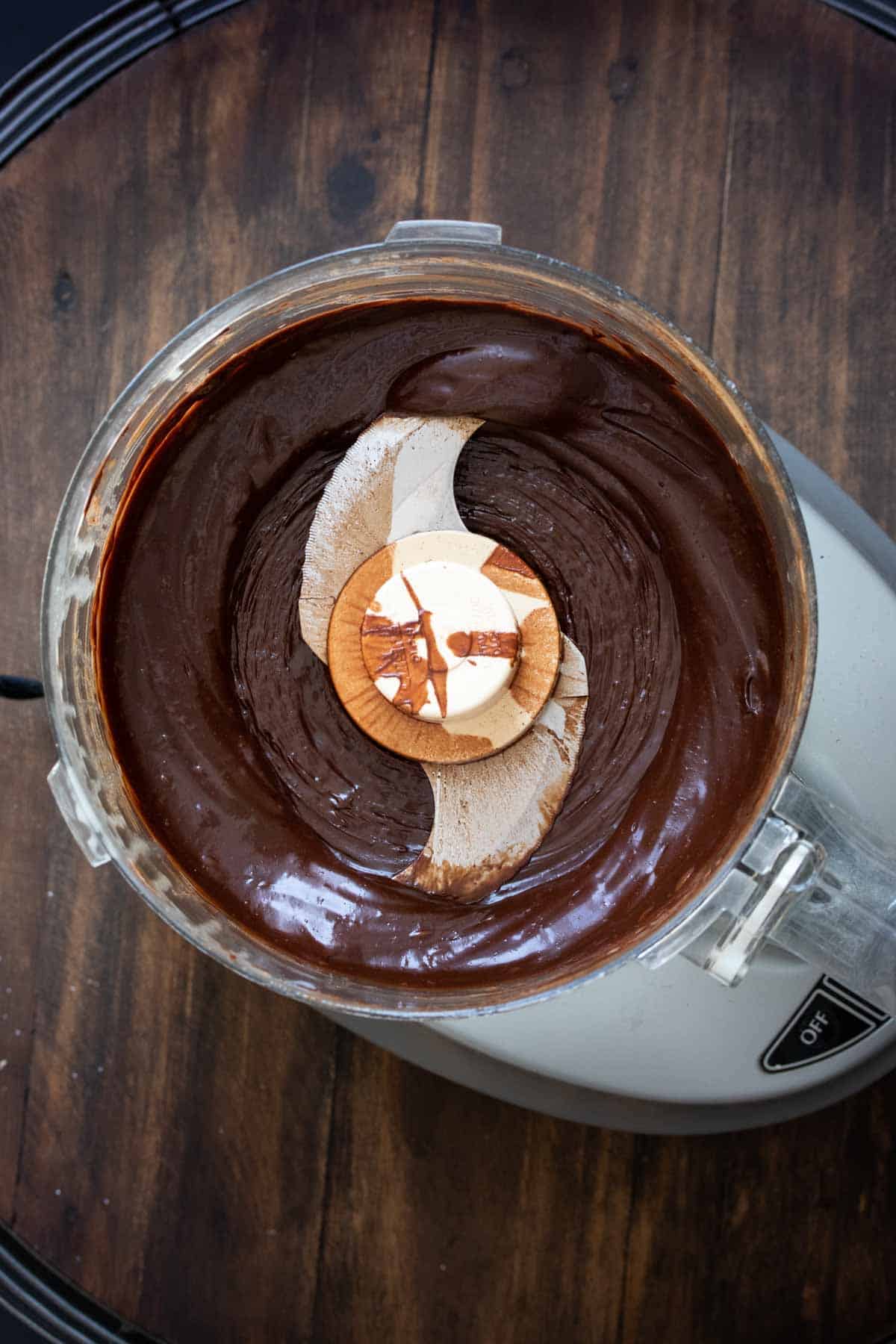 Top view of a food processor with smooth chocolate truffle mixture