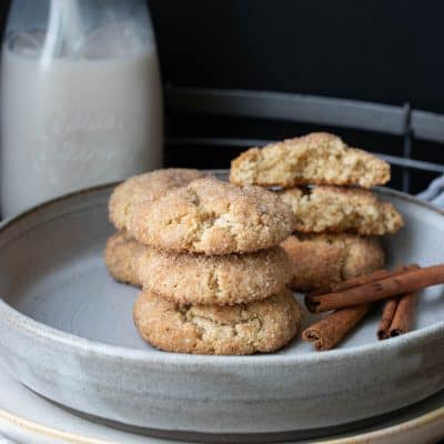 Grey plate with snickerdoodle cookies in front of a glass jar of milk