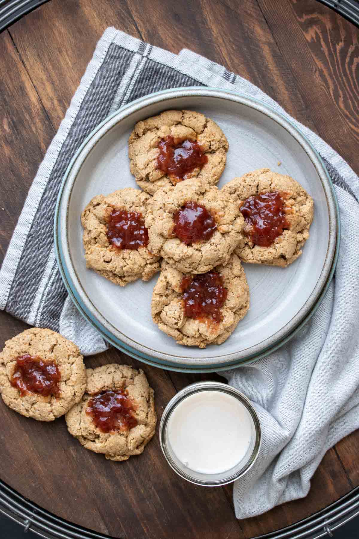 Thumbprint cookies with berry jam on a grey plate on a wooden surface