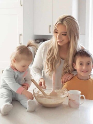 Photo of blond woman with kids baking in a white kitchen