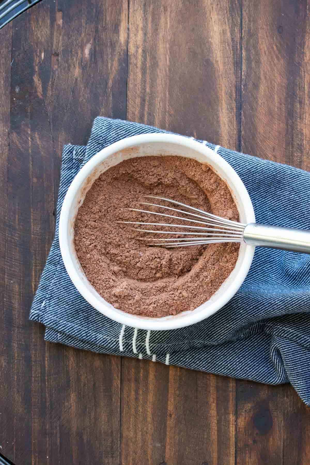 Whisk mixing hot cocoa mix ingredients in a bowl.