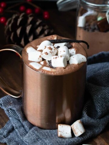Copper mug filled with hot chocolate and topped marshmallows.