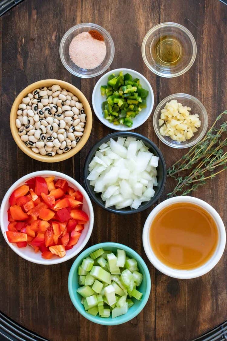 Different colored bowls filled with ingredients to make black eyed peas