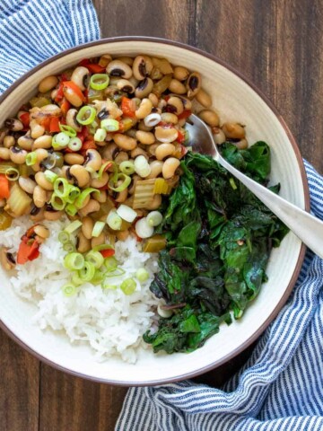 Black eyed peas, rice and chard in a cream colored bowl