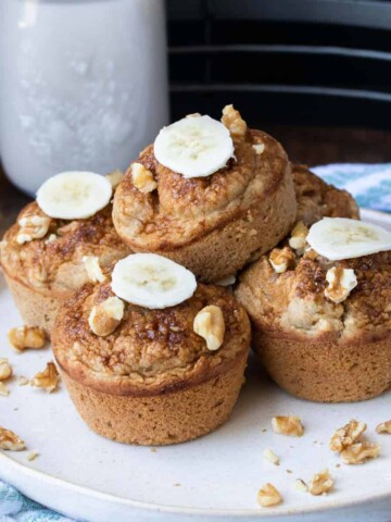 A plate with a pile of banana walnut muffins on it