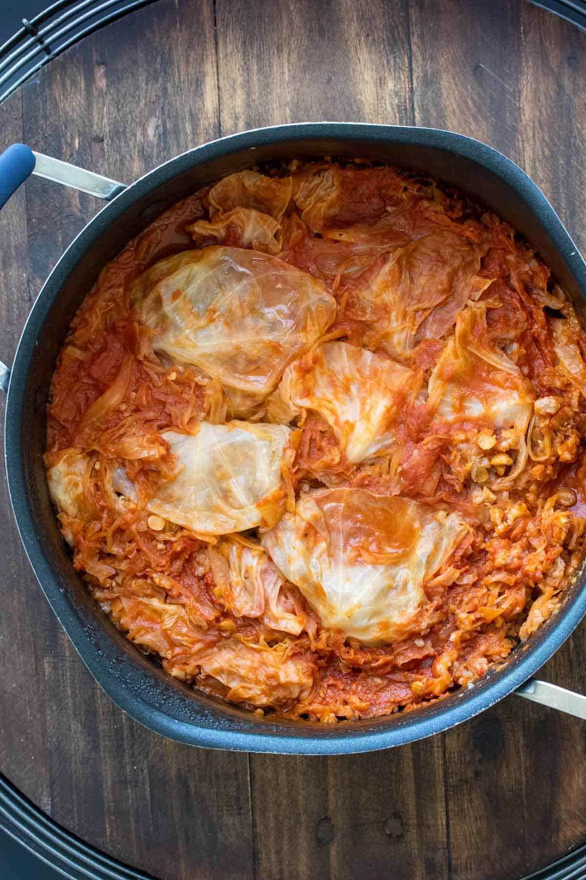 Top view of pot with cooked stuffed cabbage rolls covered in tomato sauce