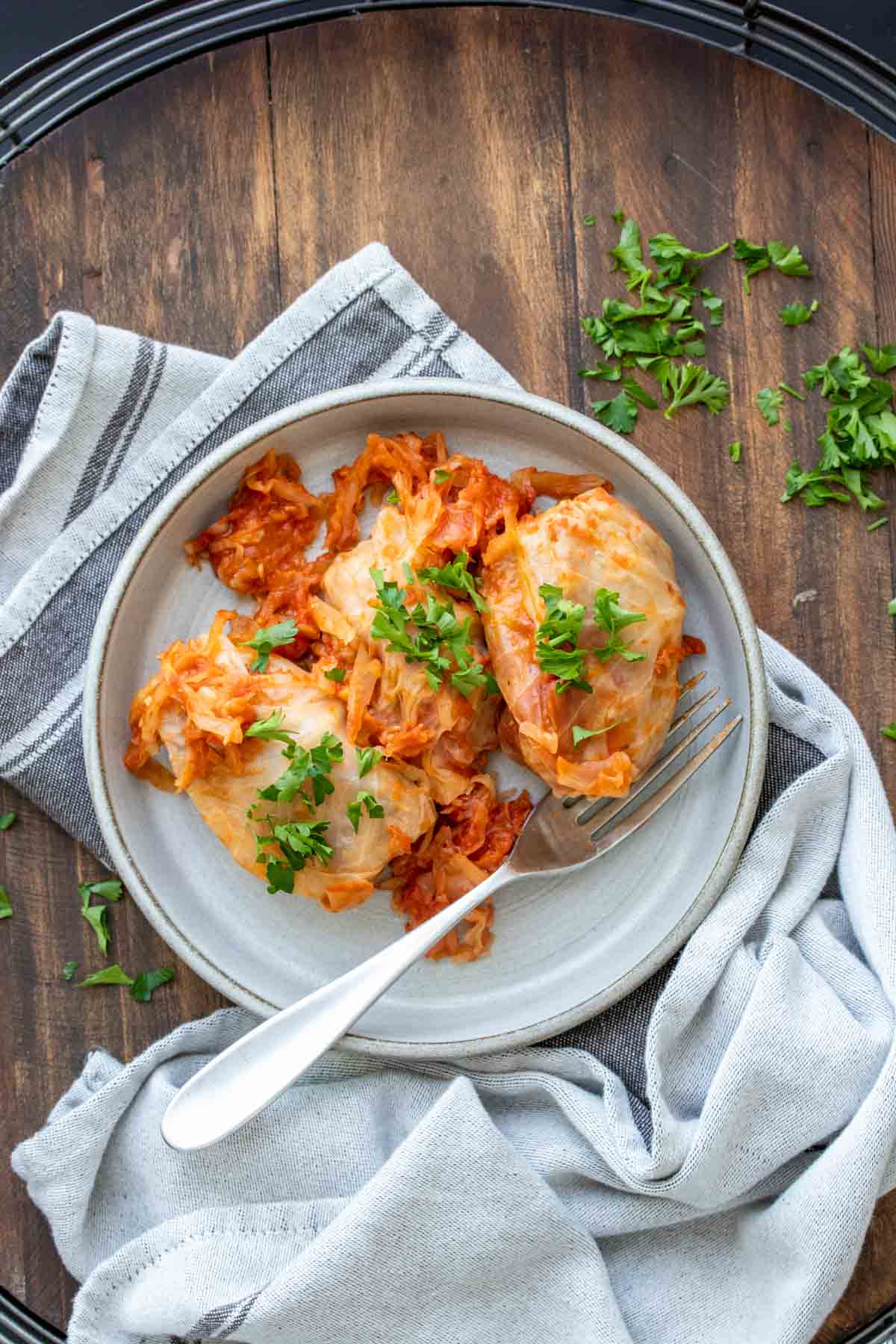 Grey plate with stuffed cabbage covered in chopped parsley