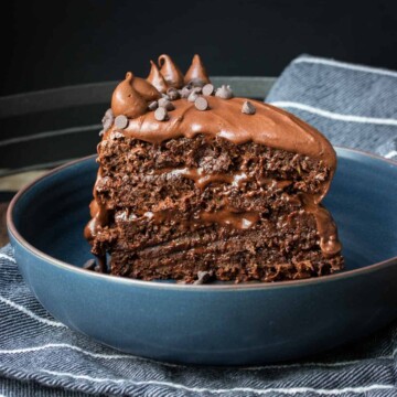 A layered piece of chocolate cake standing up in blue bowl