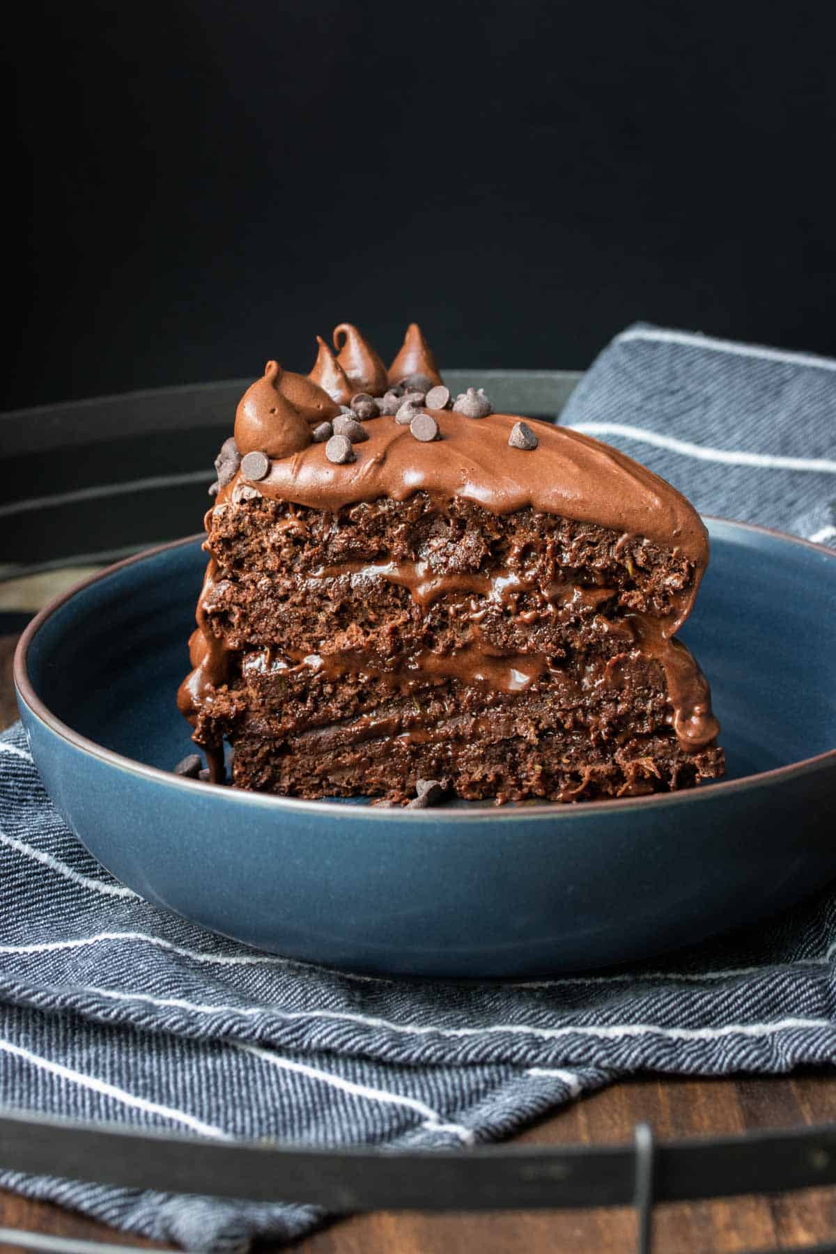 A layered piece of chocolate cake standing up in blue bowl