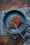 Blue bowl with a piece of chocolate cake in it laying down