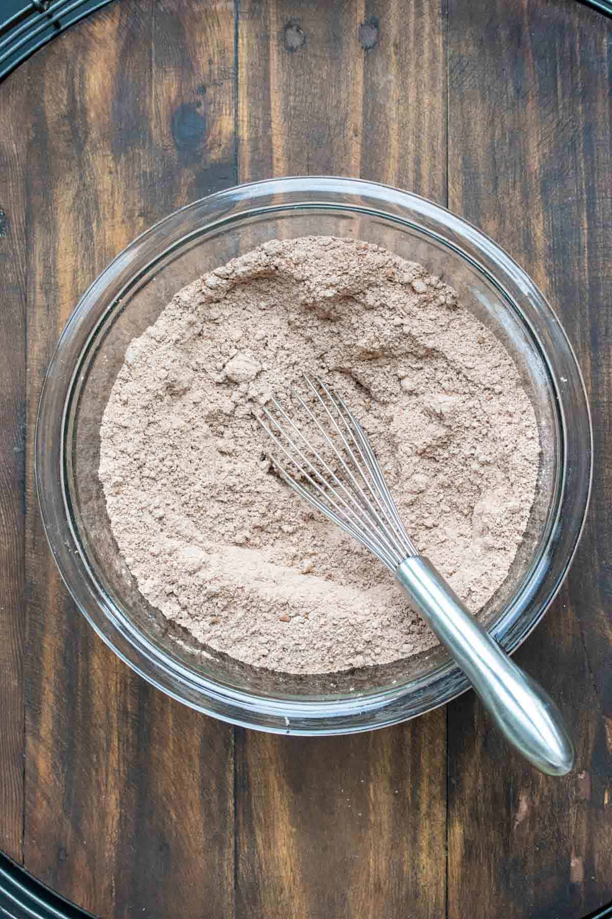 A whisk mixing dry ingredients for chocolate cake