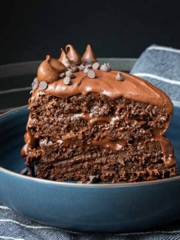 A piece of chocolate cake with frosting in a blue bowl