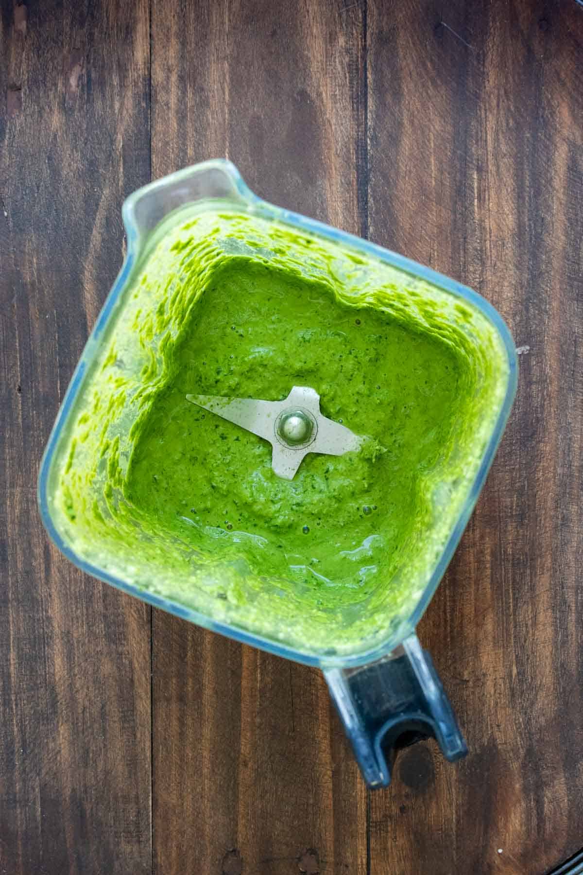 Top view of a blender with pureed kale pesto inside