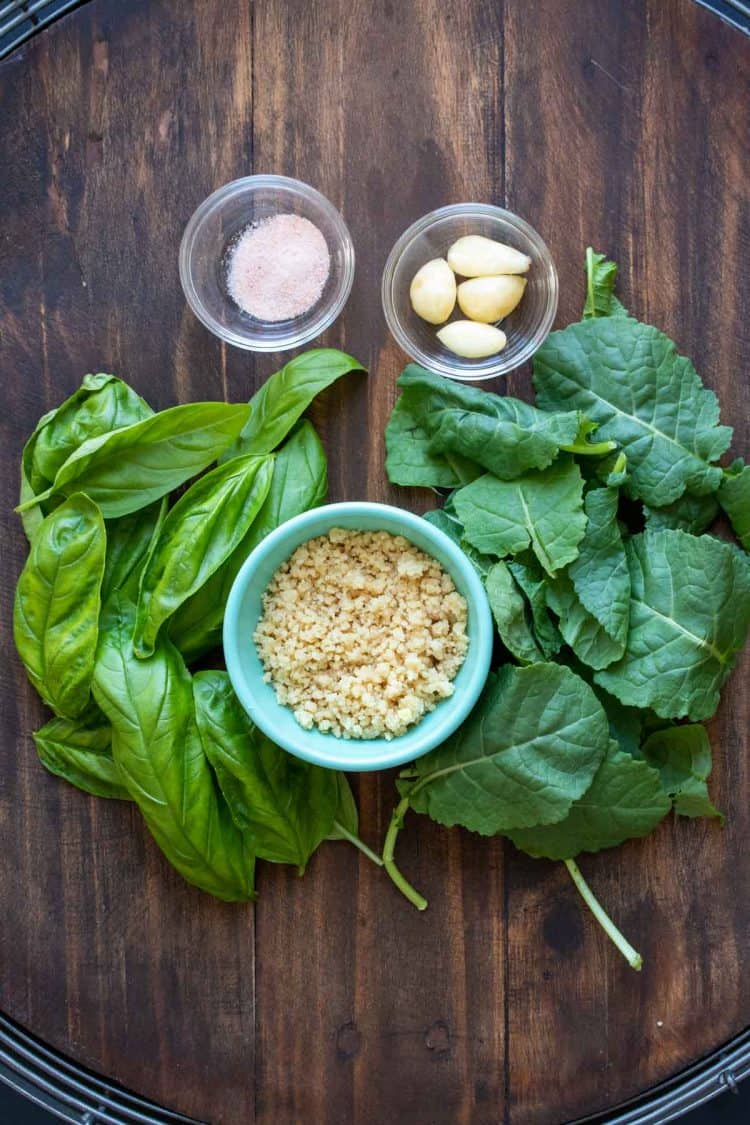 Ingredients needed to make kale pesto on a wooden surface