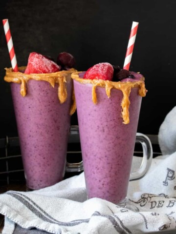 Two glass jars with peanut butter and jelly smoothies