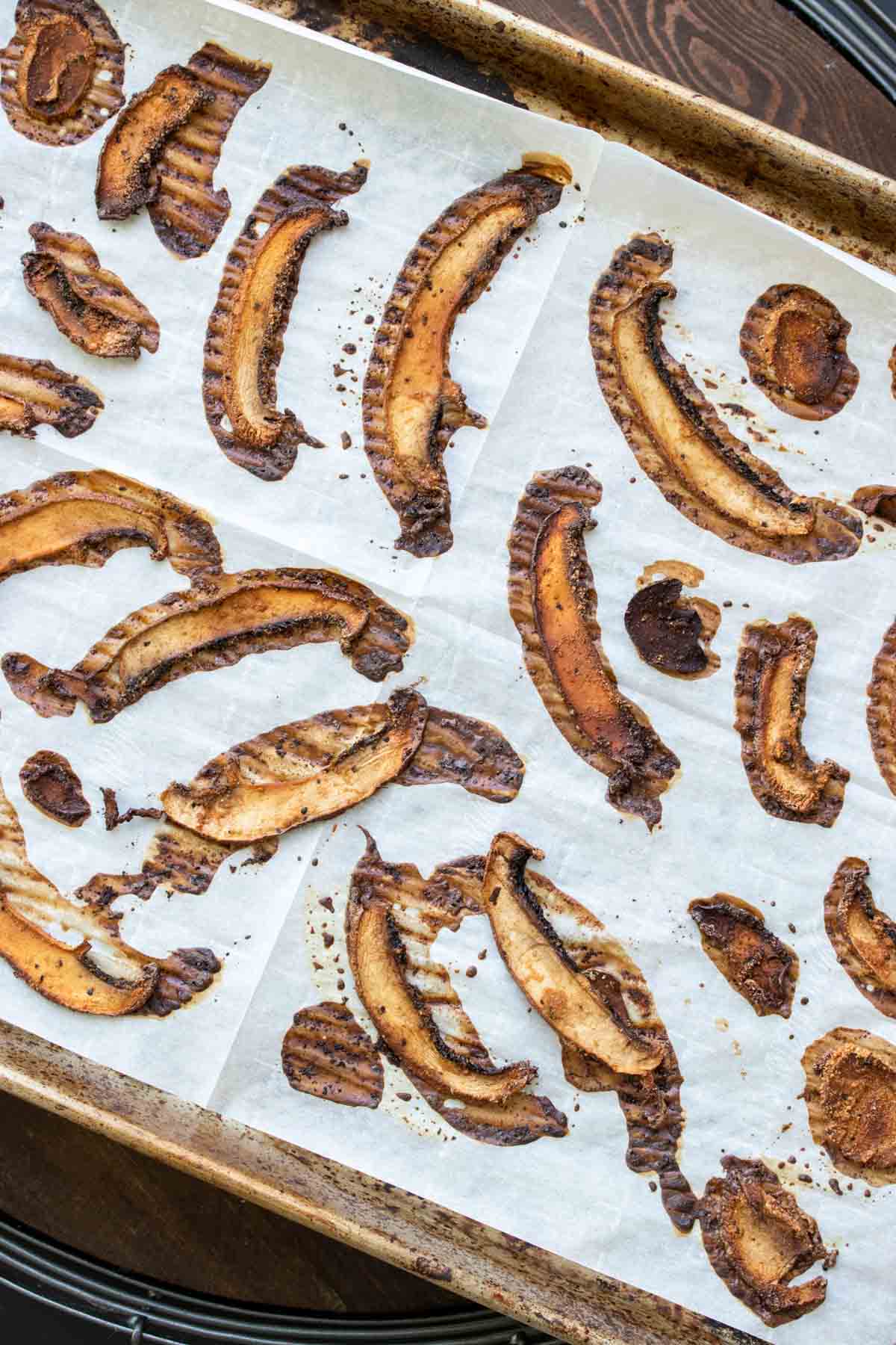 Baked slices of portobello mushroom on a baking sheet lined with parchment