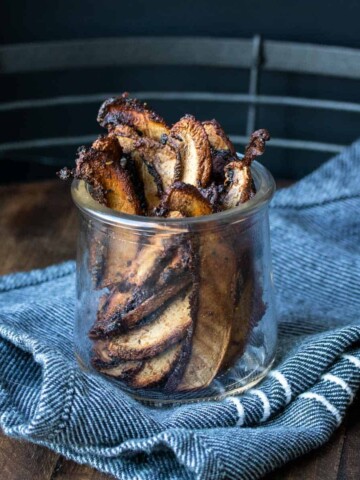 Slices of portobello mushroom that have been baked crispy in a glass jar